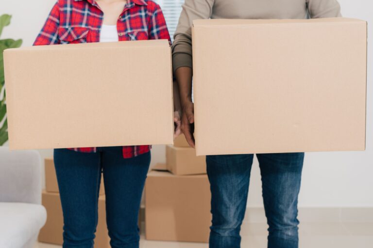 A couple is carrying boxes in the concept of moving to Walthamstow.