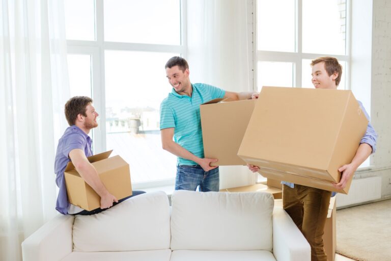 A group of male students carrying boxes in the concept of relocating to Walthamstow.