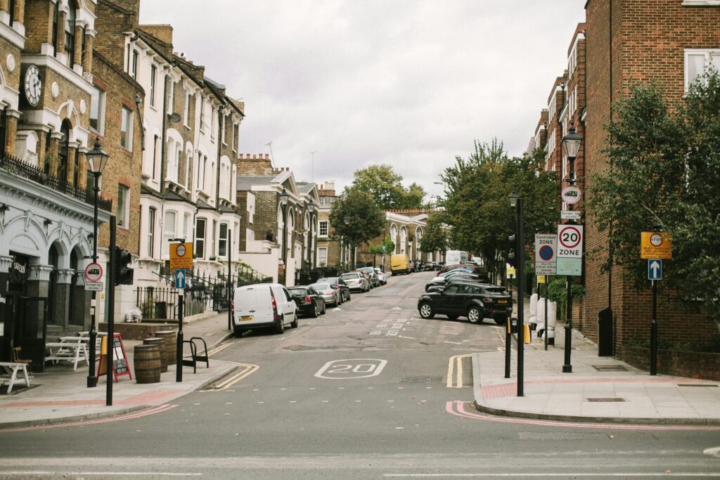 An empty residential street with cars parked lined outside